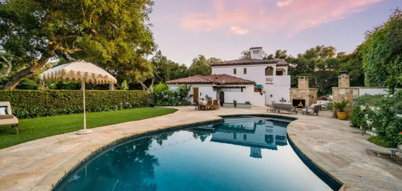 a large home with a large swimming pool in front of it