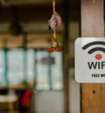 Rustic wooden post with a sign attached to it, displaying the words "Free Wi-Fi"