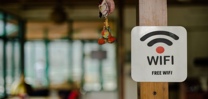 Rustic wooden post with a sign attached to it, displaying the words "Free Wi-Fi"