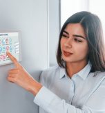 Woman is indoors controlling smart home technology