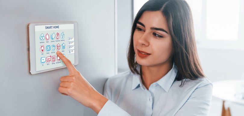 Woman is indoors controlling smart home technology